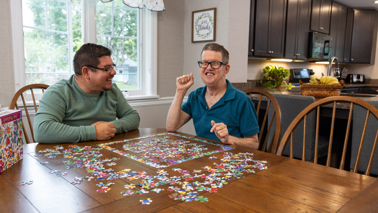 Two men working on a puzzle